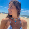 wearing blue lucky charm necklace at beach