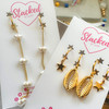 Pearl drops and cowrie shell and gold star earring stacks on earring cards