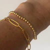 wearing paperclip chain bracelet and gold beaded bracelet