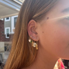 wearing glitzy skull earrings with other gold huggie hoops