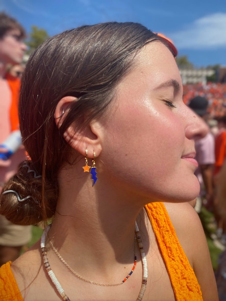 Blue mini enamel bolt earring stacked with orange statement star huggie