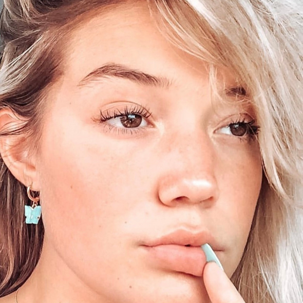 Olivia Ponton wearing teal pearly butterfly huggie hoop  earrings