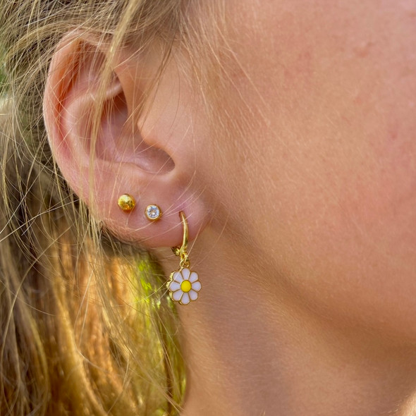 wearing gold studs, baguette studs and alex french daisy flower earring stack