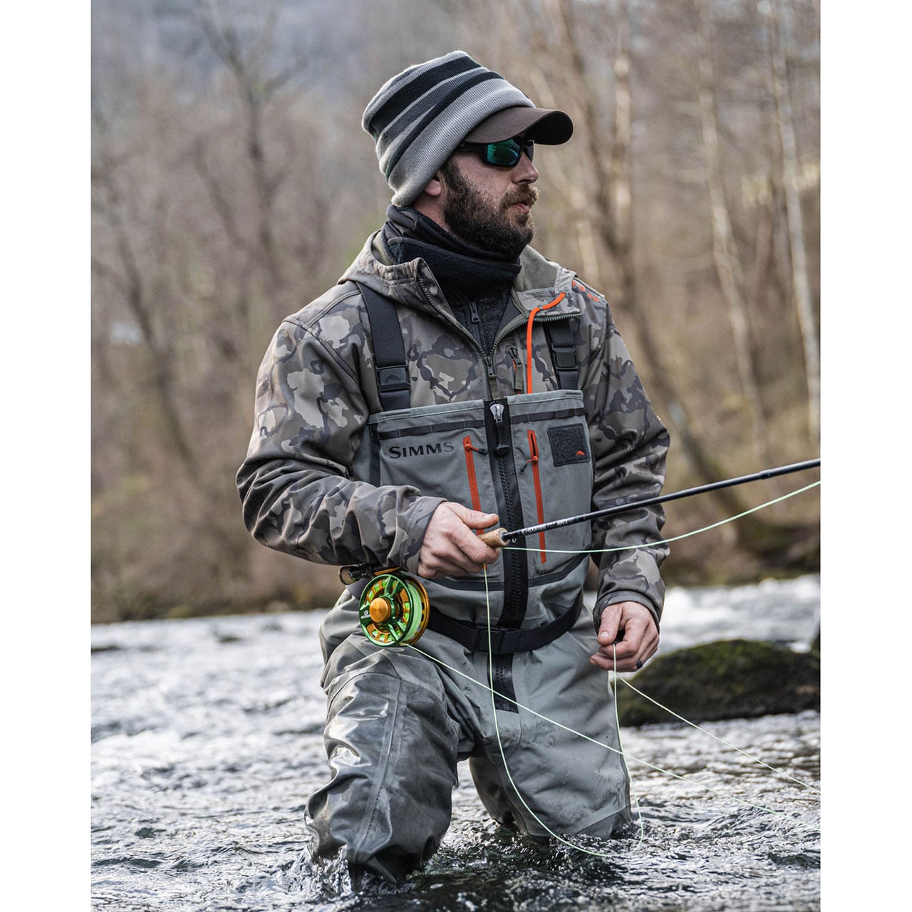 Fly fishing angler wading in stream wearing Simms Freestone Z Stockingfoot Chest Waders