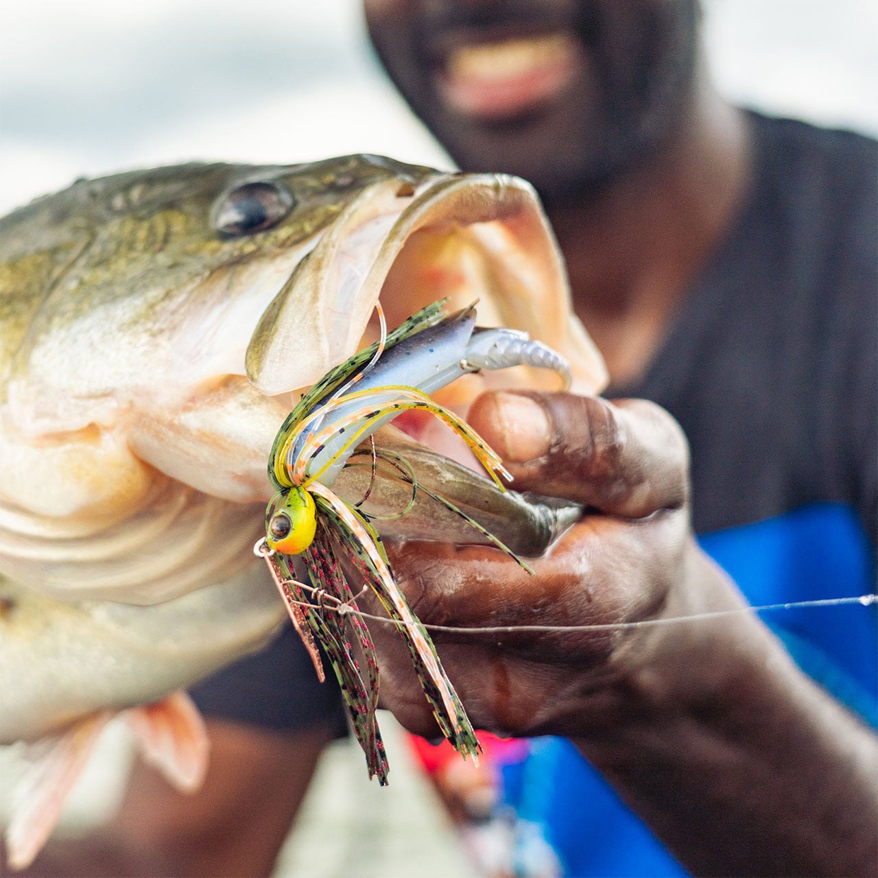 Angler holding a bass for close look of its mouth hooked by a Z-Man ChatterBait Elite Evo paired with a soft plastic trailer