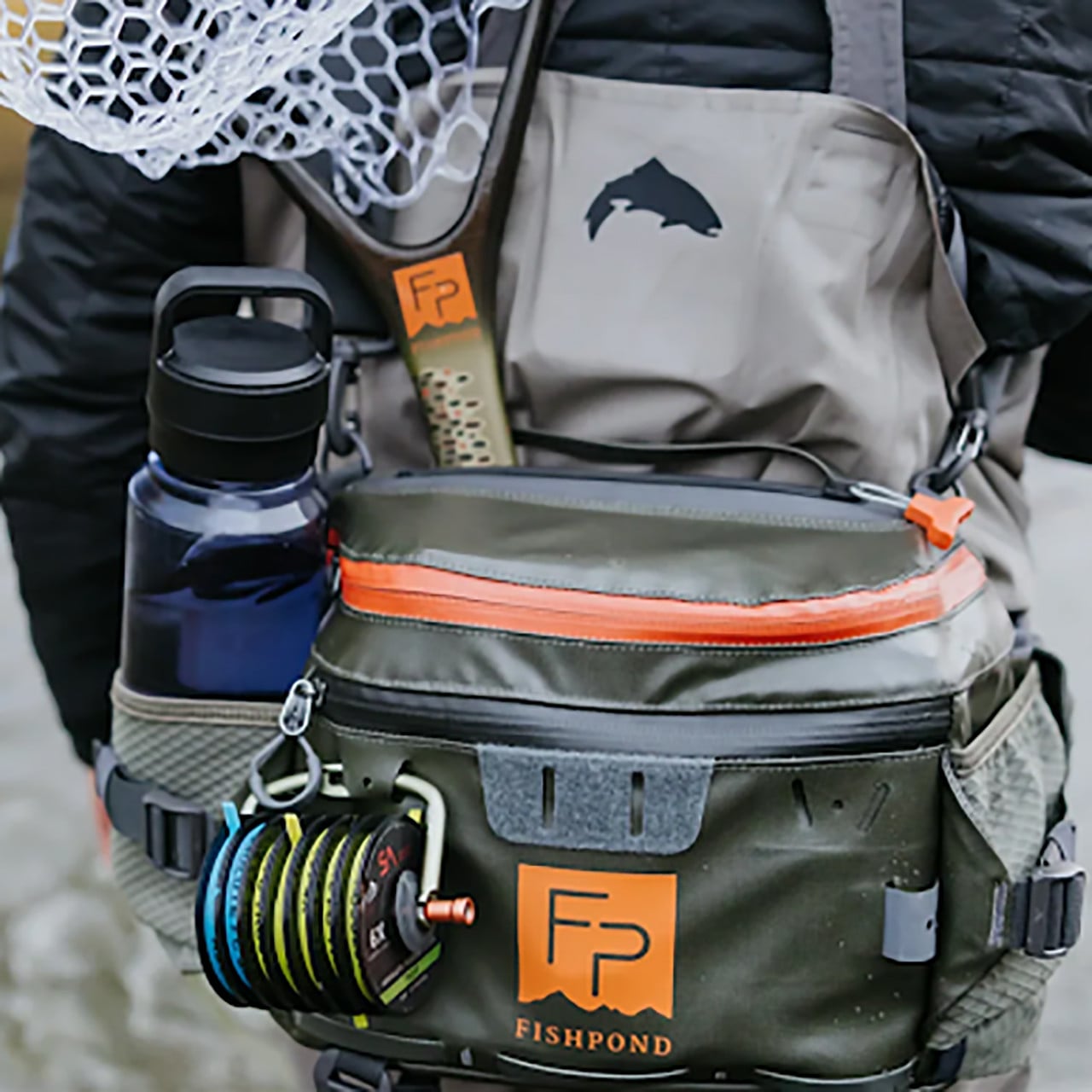 Fishpond Stormshadow Lumbar Pack on angler for size comparison (water bottle, net, tippet holder, and tippet not included)