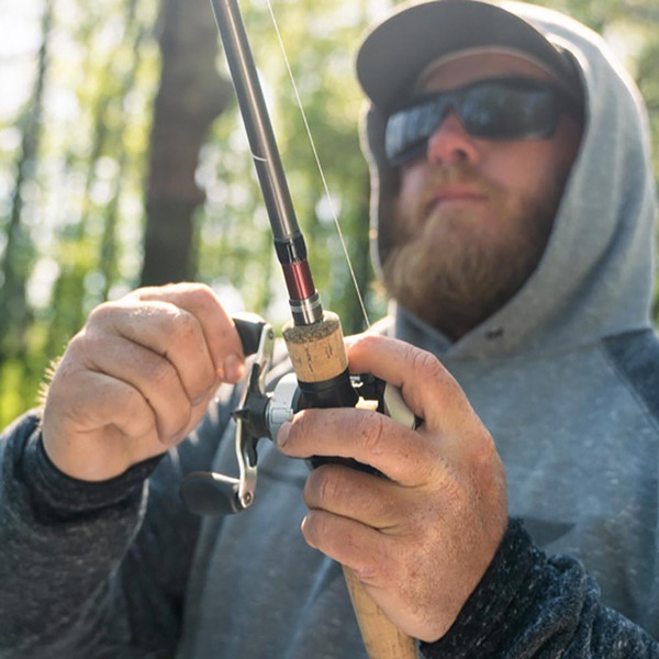 Close-up of angler's hands in foreground fishing with a Temple Fork Outfitters Professional Series Casting Rod