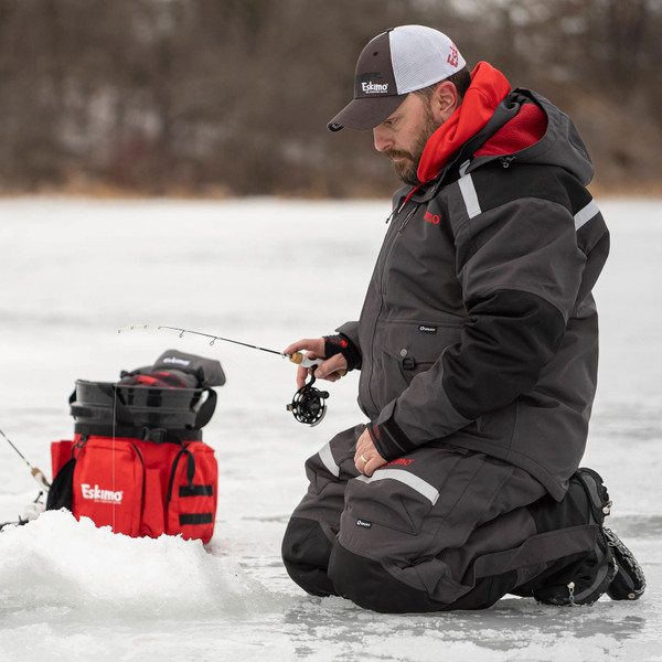 Ice Angler fishing beside an Eskimo Bucket Caddy holding accessories that are not included with the caddy