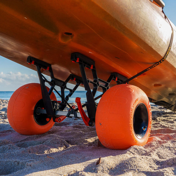 YakAttack TowNStow Bunkster Kayak Cart with Sand Tires on the beach loaded with an orange kayak