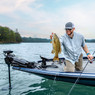 Garmin Force Trolling Motor mounted on boat with an angler holding a smallmouth bass