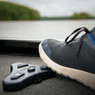 Close up of a sneakered foot using a Humminbird Mega Live TargetLock Foot Pedal onboard a boat deck