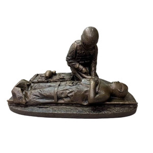 A military statue of a male soldier medic, 8.5 inches tall, 12 inches long, and 8 inches wide, with a slot for a challenge coin in the front, and no wooden base.