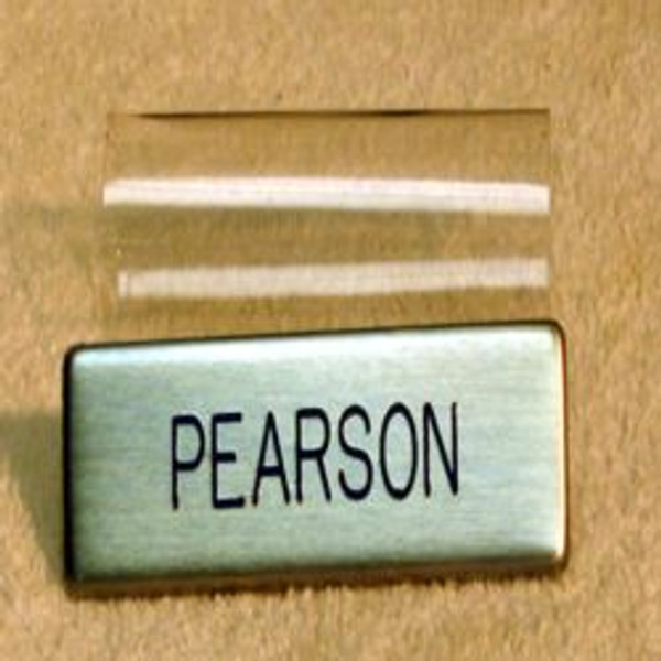 U.S. Air Force dress regulation military name badge metal, silver with blue letters with plastic enclosure. 3 inches long by 3/4 inch high. Call if expedited service is required. Ships within 48 hours when ordered by 12 Noon Eastern Time.