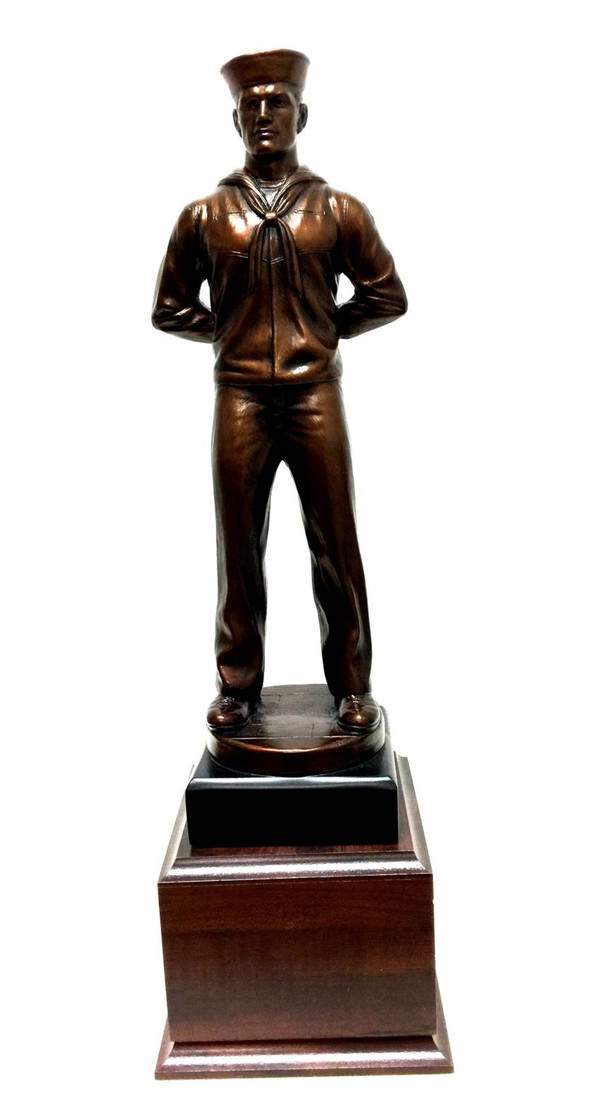A bronze tone military statue of a sailor at parade rest, 18 inches tall, on a laminated cherry base that measures 6.5 by 6.5 by 2.5 inches, with complimentary engraving.