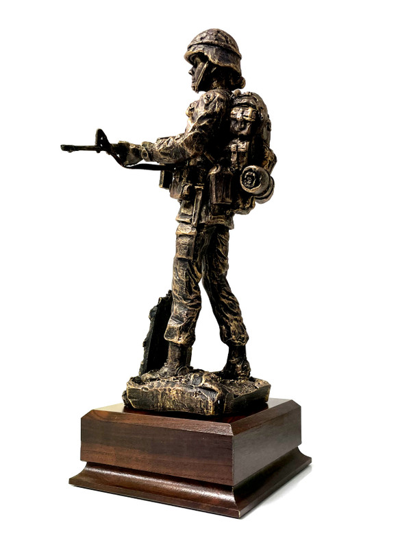 A military statue of a female soldier, 11 inches tall, stands on a laminated cherry base that measures 5.5 inches by 5.5 inches by 2 inches. The statue has a total height of 13 inches. The base has an Army medallion that can be replaced if needed.