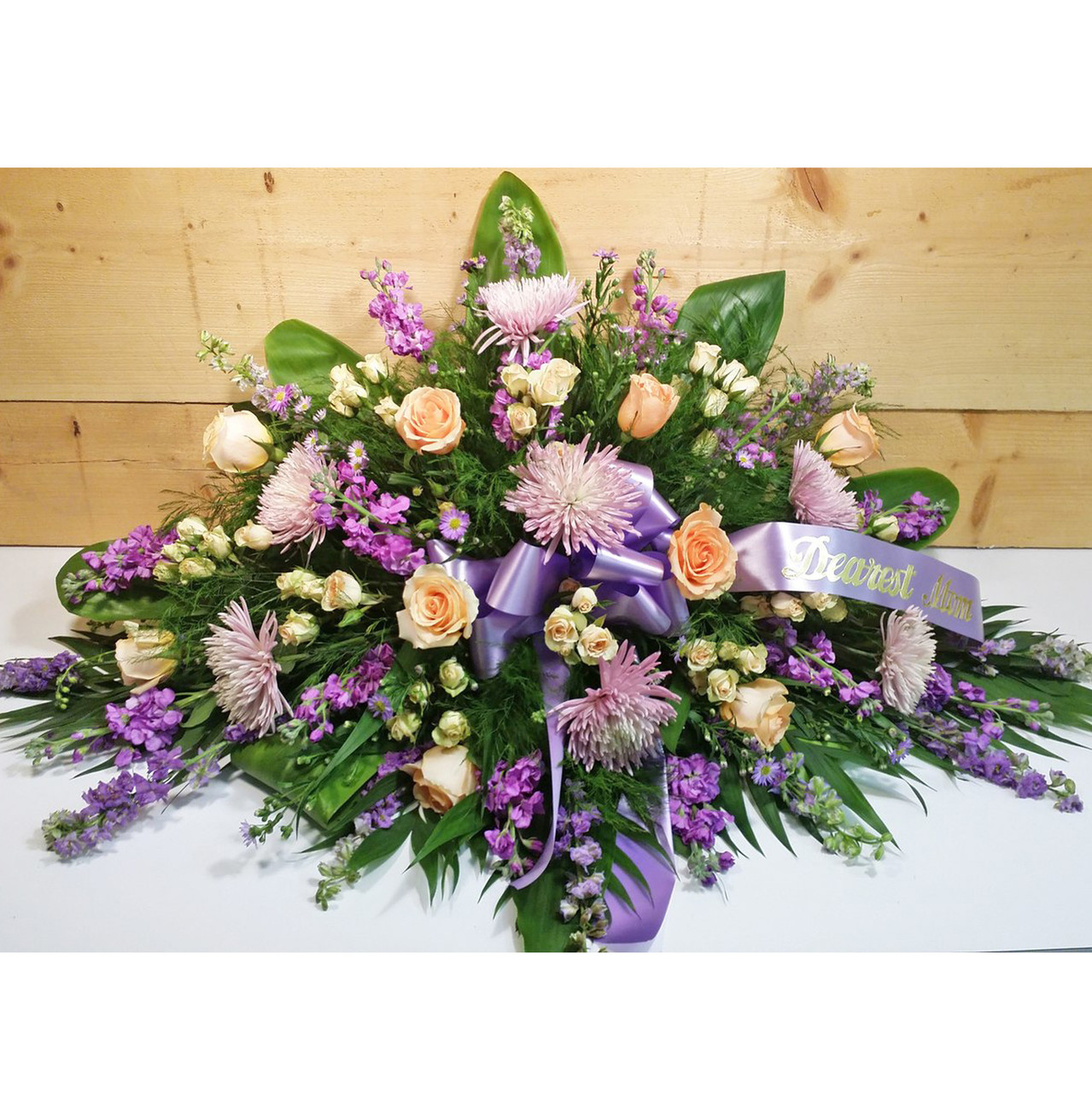 Shades of lavender and purple flowers in a funeral spray  Church flower  arrangements, Funeral flower arrangements, Funeral flowers