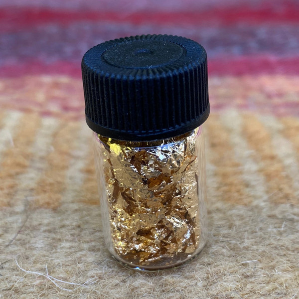 Gold Flakes in a Glass Bottle