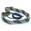 Green and white woven shotgun bore cleaner with black cord and tassel.