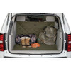 Green quilted cargo protector in a white SUV cargo area, with boots, bag, and mesh bag.