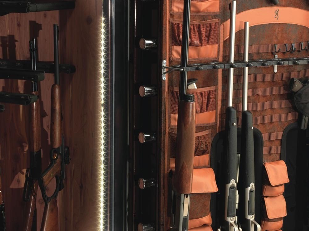 Browning safe interior with guns, leather pockets, and LED lighting.