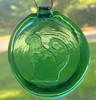 Green glass suncatcher with a sitting cat design. The background is foliage.