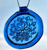 a blue, round glass suncatcher with a relief image of a dahlia blossom