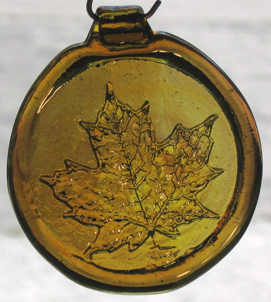 a round, yellow glass suncatcher with a relief image of a maple leaf