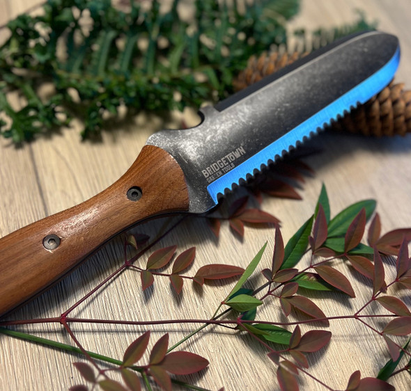 Essential Hori Hori knife on a table with freshly cut greens