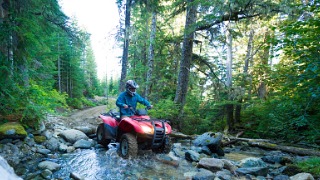 ATV riding in rough streambed