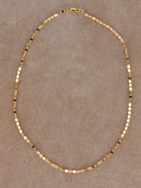 The Paloma Necklace is crafted from luminous 14k gold-filled flat oval links each link reflecting light like tiny mirrors for a fluid, glowing effect.