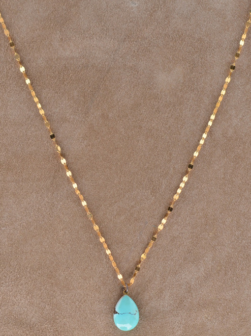 Genuine turquoise teardrop pendant necklace suspended from the Angela West Designs Paloma 14K gold-filled chain, displayed on a model.