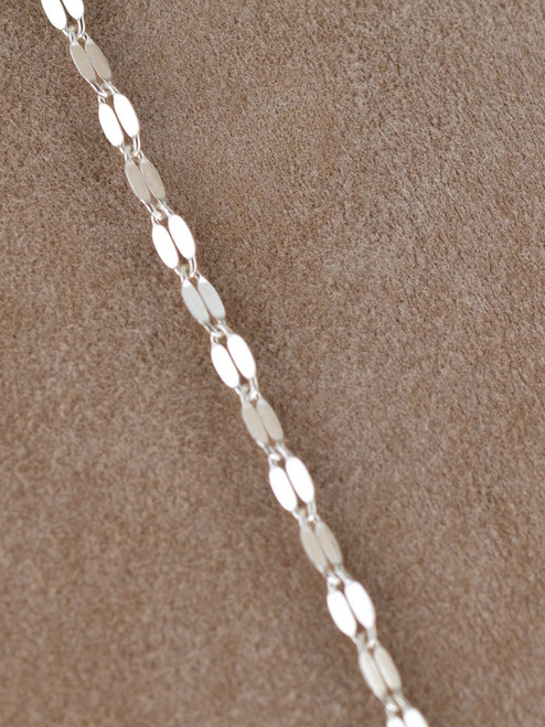 The Valencia Layers Necklace is a striking multi-chain necklace crafted from sterling silver links, designed to float and shimmer on the neckline.