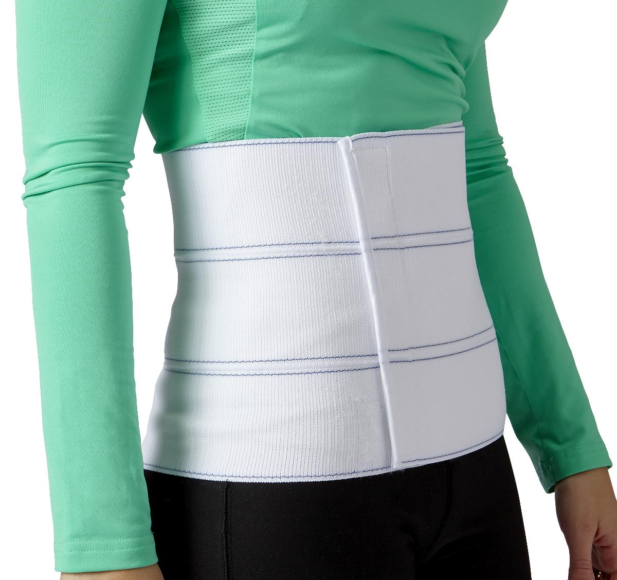 Person wearing a white abdominal binder around the waist under clothing, showing Velcro closure and support