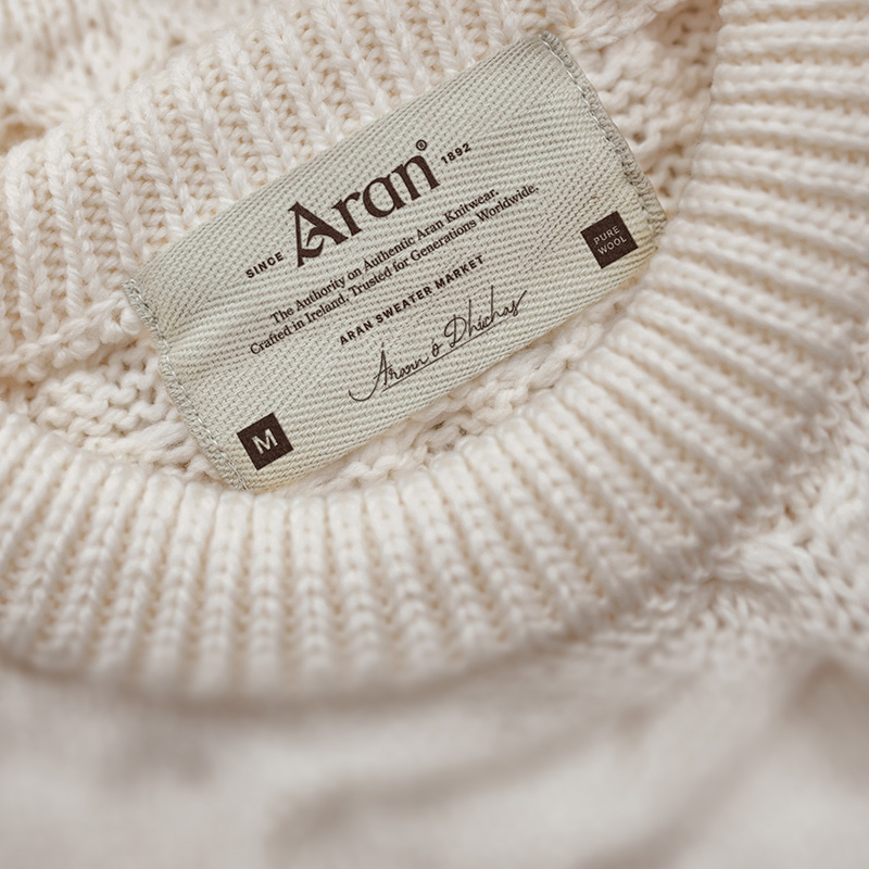 Aran label stitched inside the collar of a cream hand-knit sweater