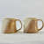 Start your morning off right with this hand thrown porcelain mug featuring three gold bees as well as äóìdropsäó of 22k gold luster. This two toned honey beige and white glazed mug holds around 10 to 12 oz, making it the perfect mug for your morning jolt of energy.