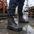 Worker wearing Oliver composite toe waterproof insulated work boots on a wet outdoor jobsite