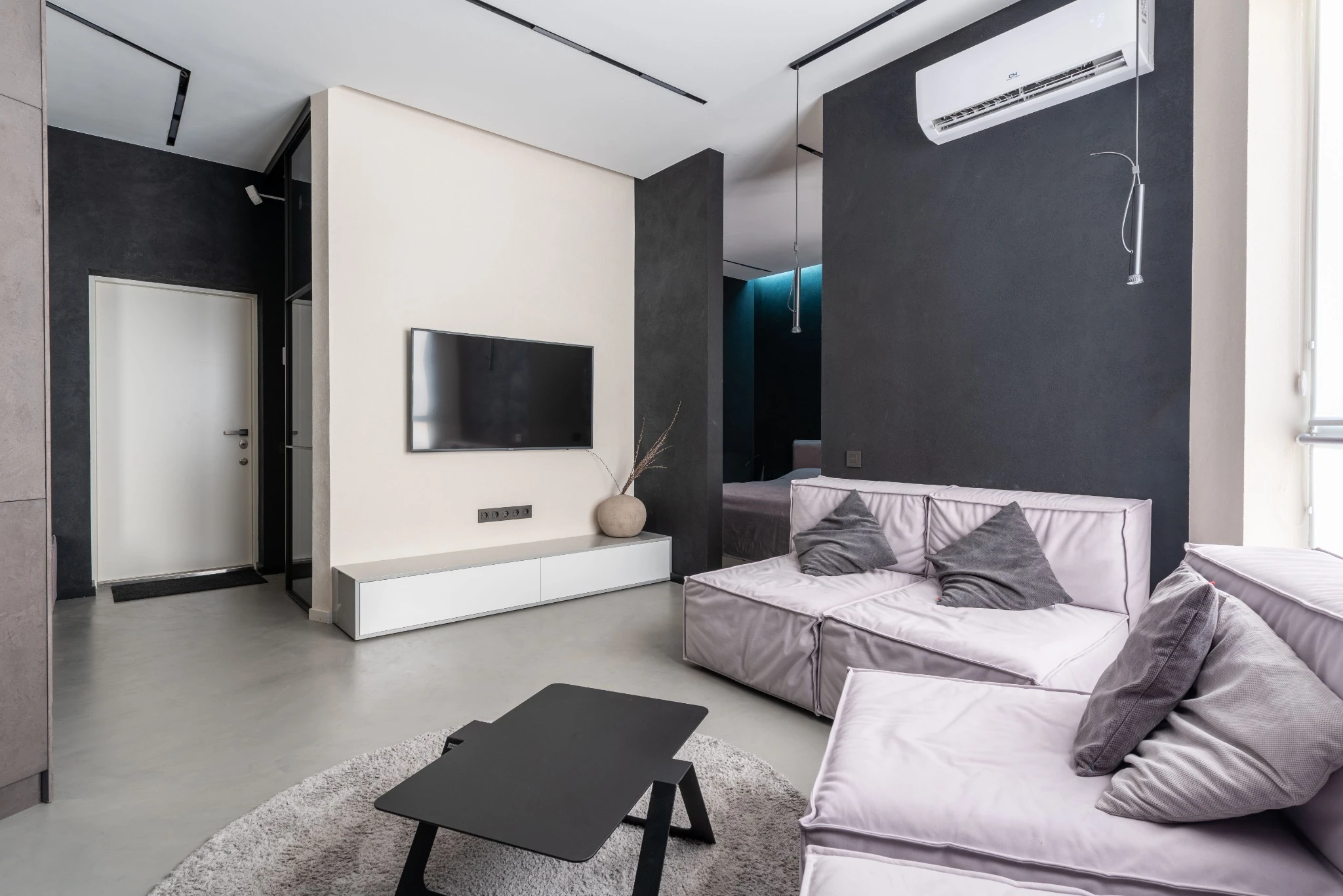 Wall-mounted television above a low cabinet in a modern lounge