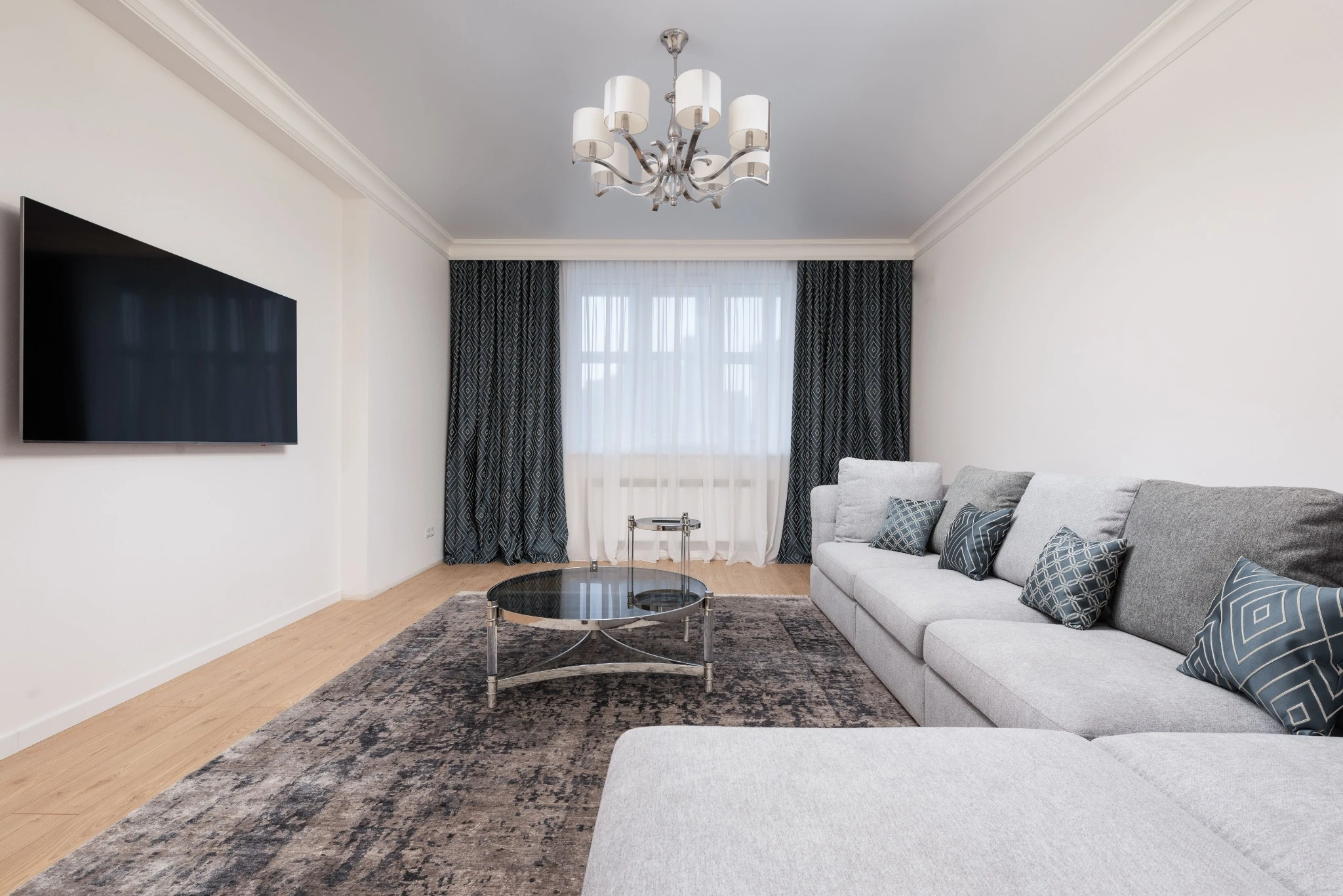 Large wall-mounted television in a bright living room
