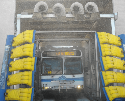 A bus exiting a large car wash.