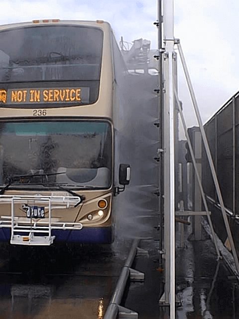 Transit bus going through commercial vehicle wash system.