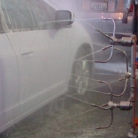 Water jets spraying car in automated car wash