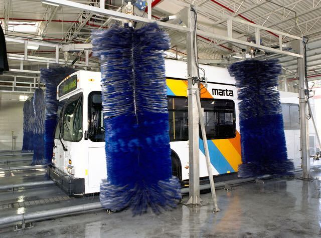 MARTA transit bus undergoing exterior cleaning in an automated bus wash system to remove road grime and maintain fleet appearance.