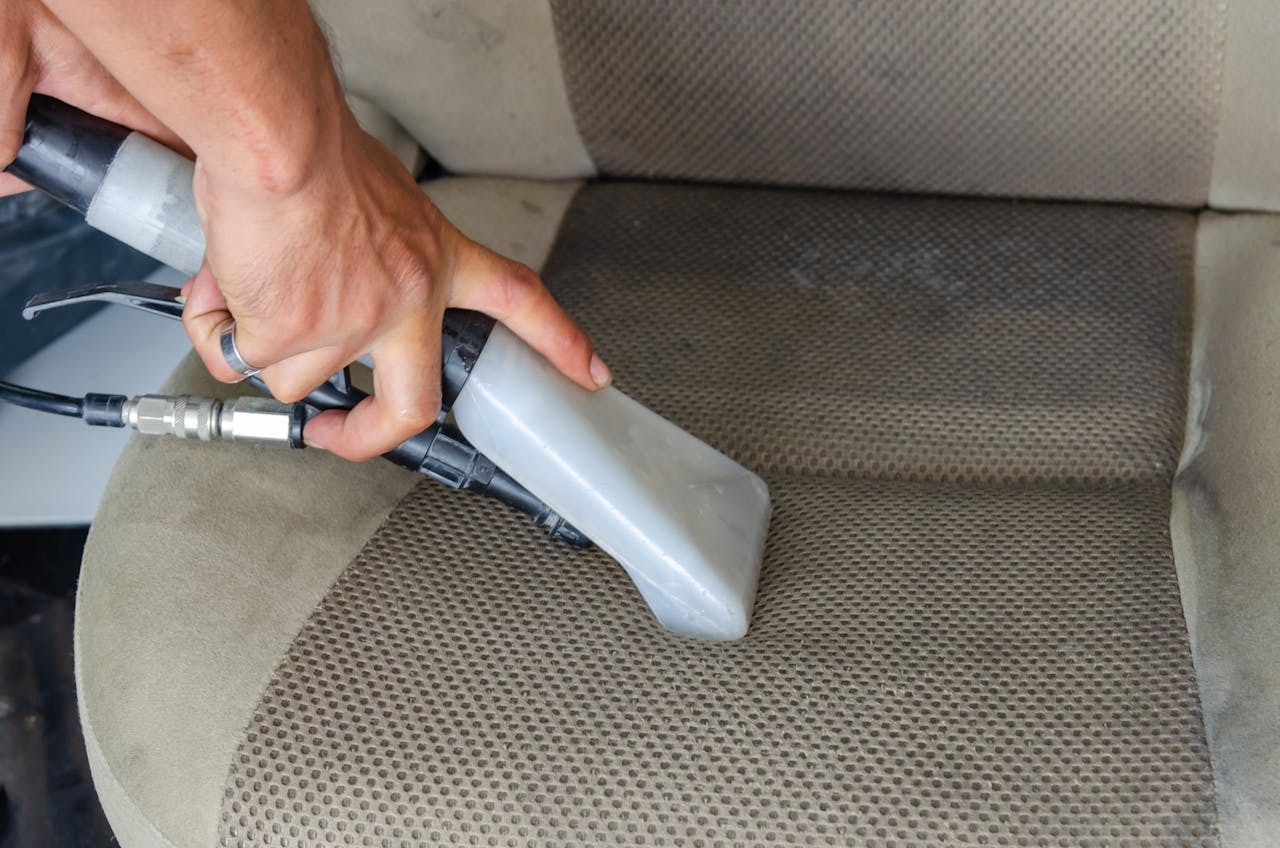 person vacuuming car seat