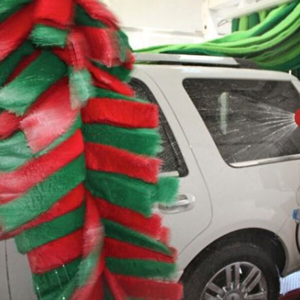 Vehicle passing through fleet washing system