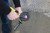 Hands mounting a 4-1/2" silicon carbide semi-flexible grinding disc on an angle grinder.