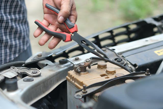 A man disconnecting a car battery cable