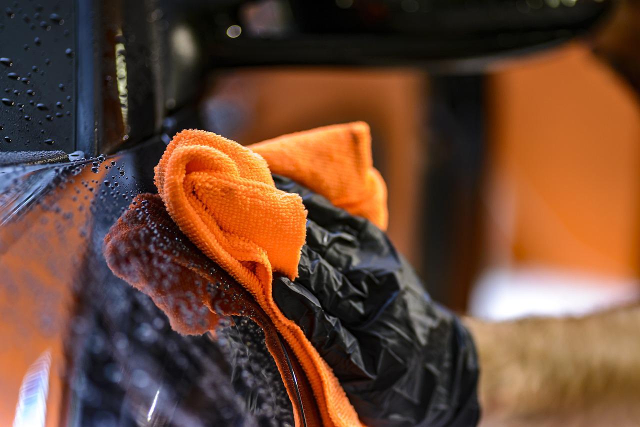 black-glove-hand-car-orange-rag