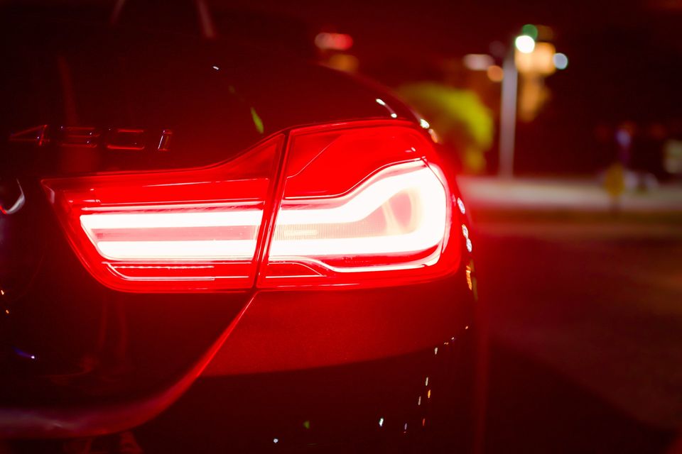 the back end of a car with its brake light illuminated at night