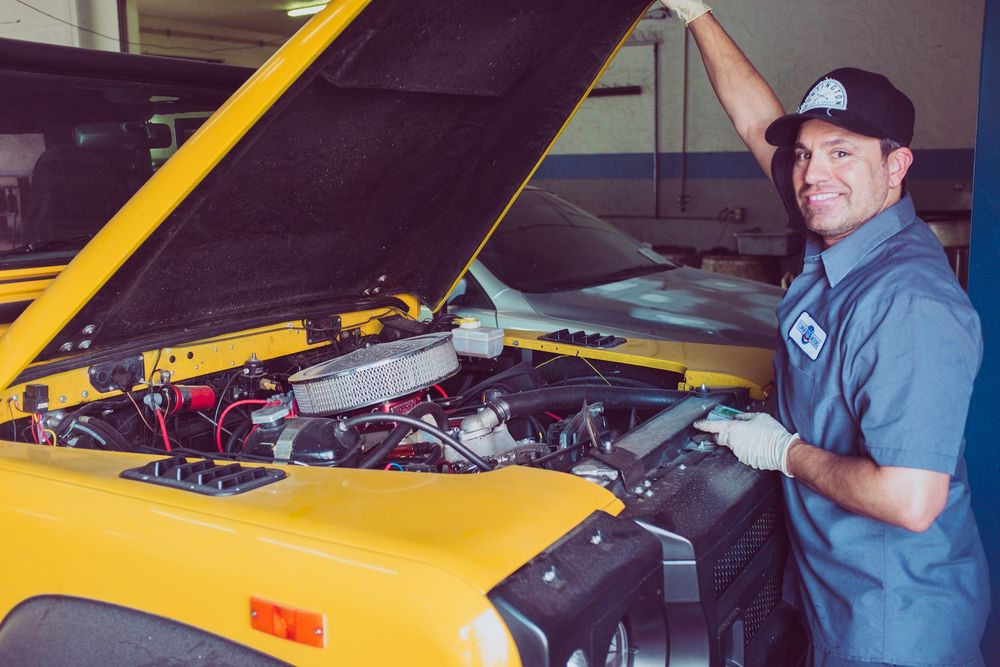 a mechanic opening the hood of a car