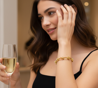 Barbed Wire Bracelet, a bold and modern bracelet featuring a unique design of interconnected gold links, crafted in 18K gold-plated stainless steel, and displayed on a model in a bright indoor setting.